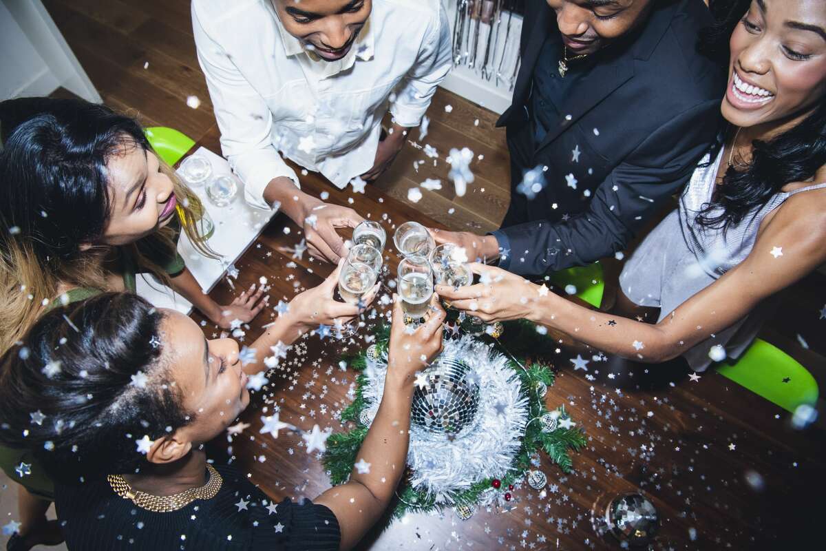 A group of young people celebrating New Year's Eve with a glass of champagne. 