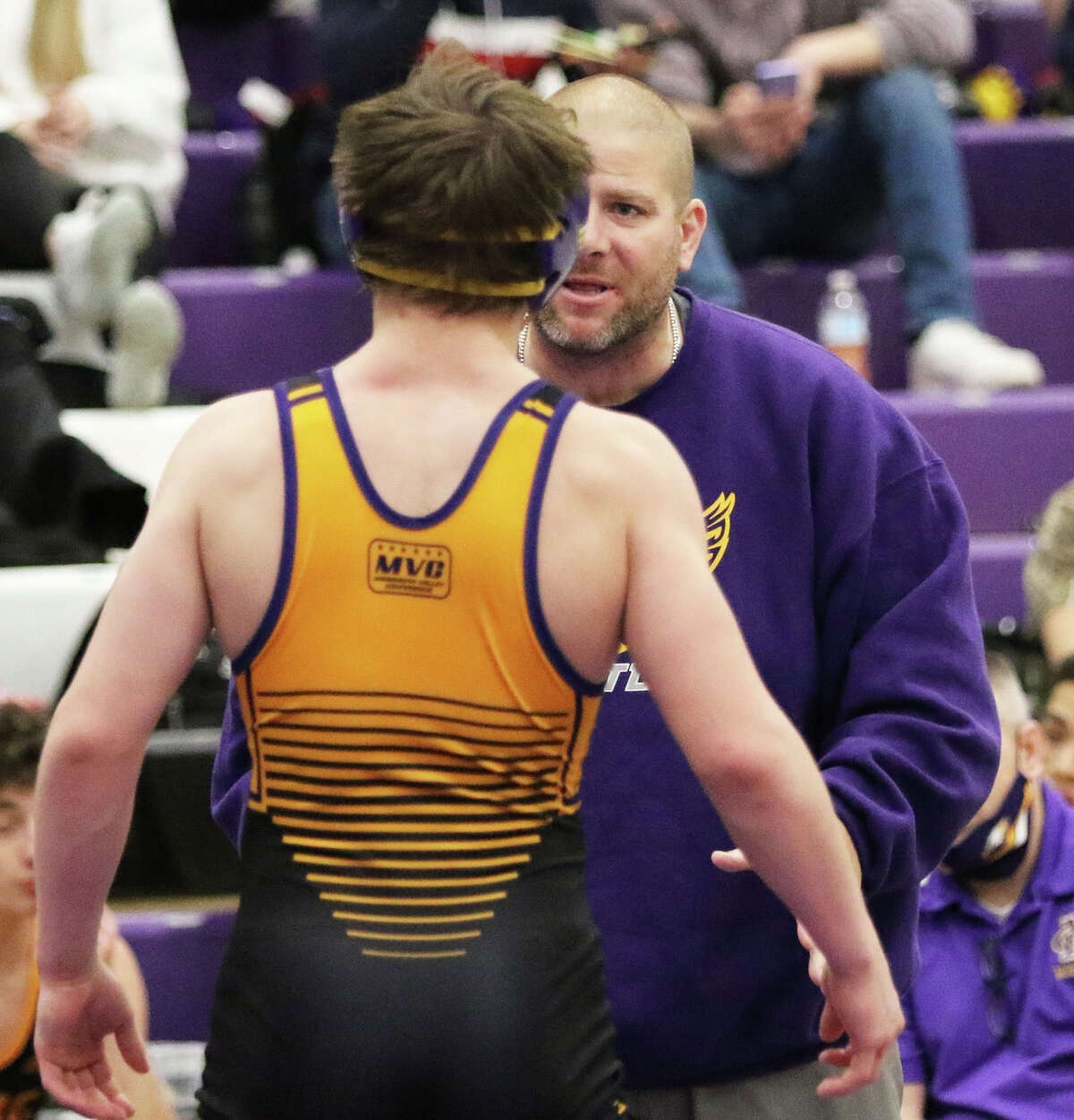 CM's Bryce Griffin listens to Eagles coach Jeremy Christeson (back) during Griffin's 138-pound championship match Saturday at the Mascoutah Tournament.