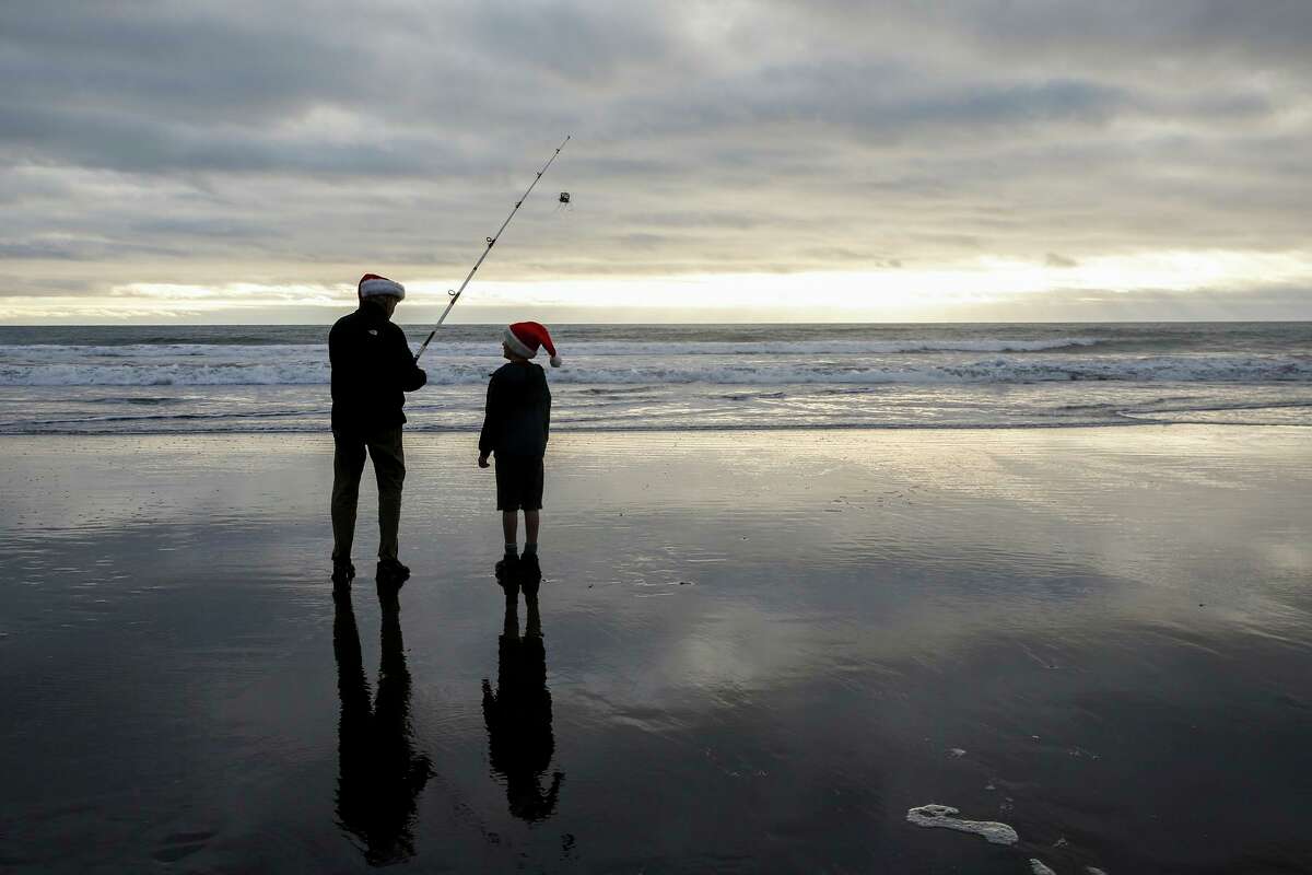Jamie Sutton and grandnephew Jaxson, 8, fish at Stinson Beach on Dec. 19. A cold snap this week is expected to bring rain.