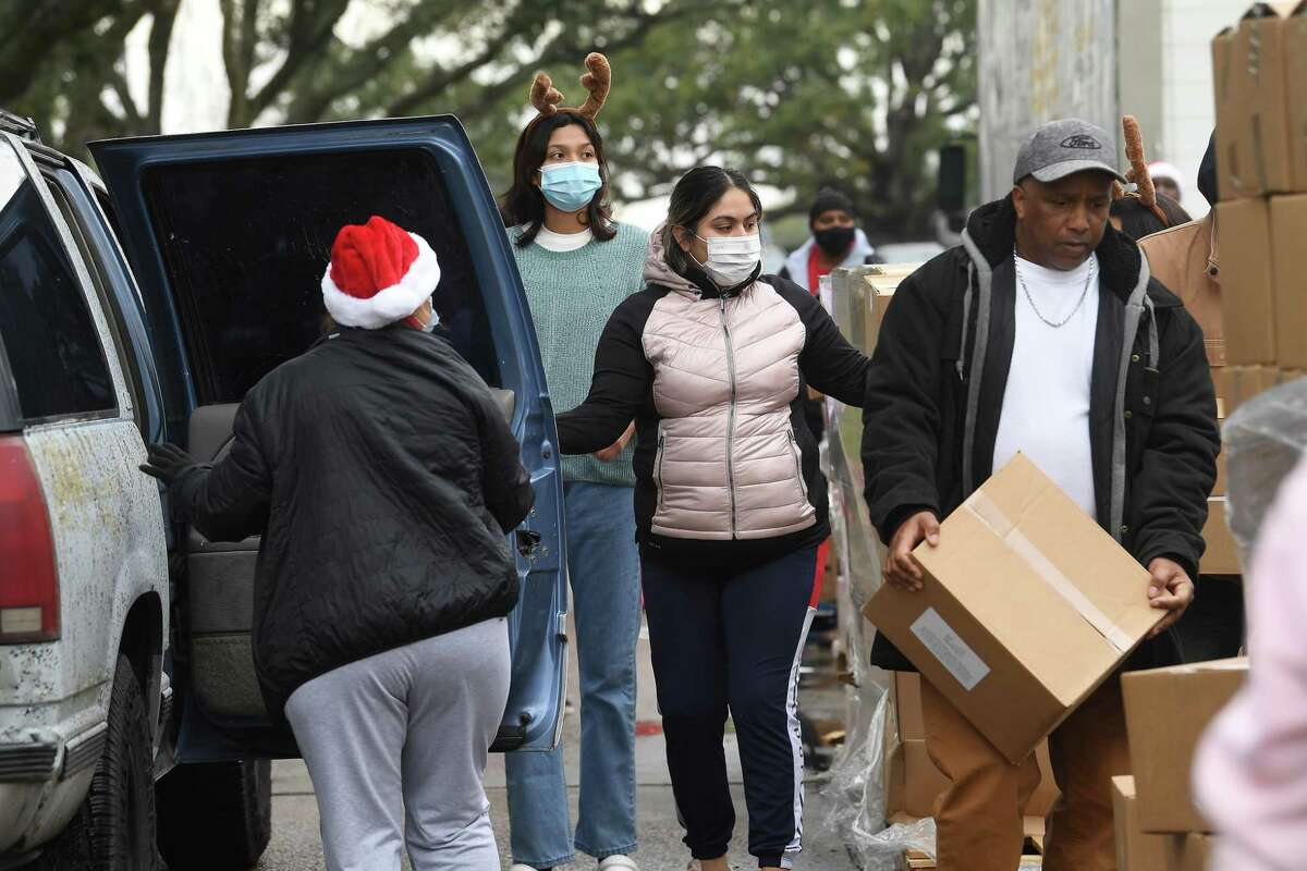 Volunteers help distribute holiday food boxes filled with produce and essentials and turkeys during a Southeast Texas Food Bank holiday distribution Monday in Port Arthur. In all, 500 turkeys and boxes were given out to help families this holiday season. Photo made Monday, December 20, 2021 Kim Brent/The Enterprise