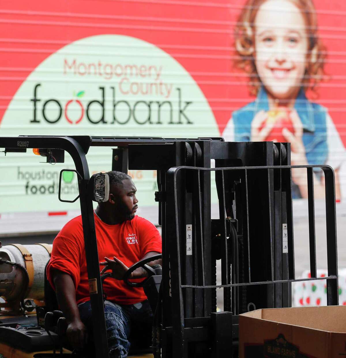 Justin James helps moves sorted donated goods during Montgomery County Food Bank’s annual holiday food drive, Saturday, Dec. 4, 2021, in Conroe. Last year, the non-profit received 70,000 pounds of food.