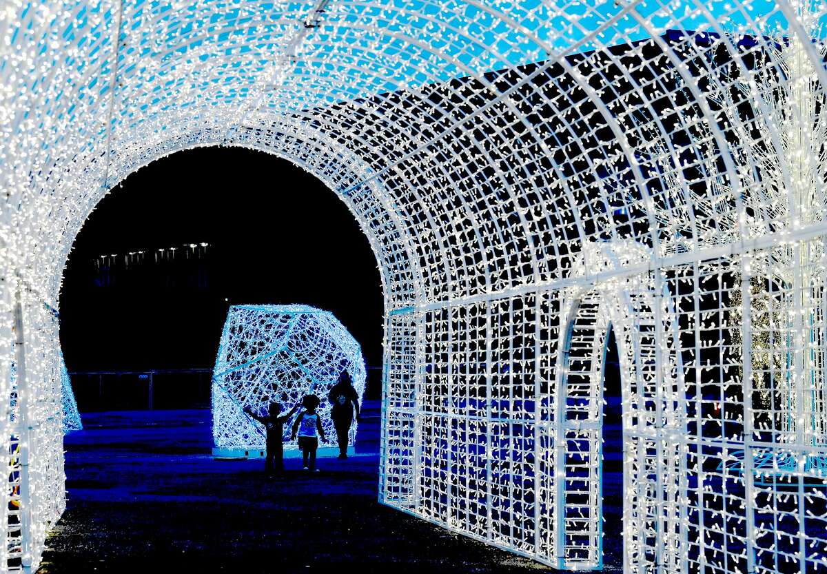 Families take in the wonder of nearly one million lights twinkling among the displays at the Holiday at Ford Park Southeast Texas Lights event. Ice skating, a petting zoo, food, vendors, a beer garden and entertainment are among the extras that round out the event which runs through January. 2, 2022. Photo made Friday, December 17, 2021 Kim Brent/The Enterprise