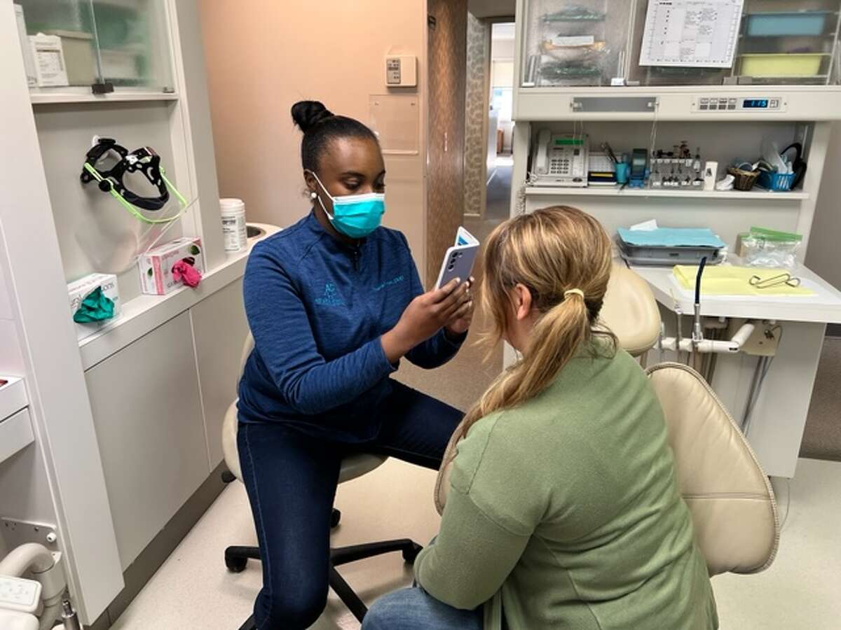  Dr. Briana Byrnes takes photographs of Dana Brighton's mouth and teeth in preparation for extensive dental work and cosmetic surgery. 