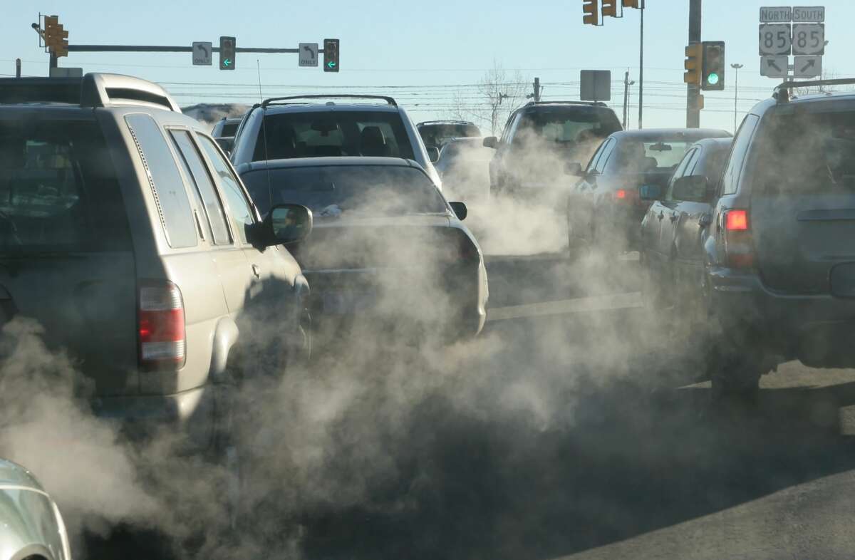 At an intersection in Denver, Colo., exhaust pours out of a tailpipes from accelerating vehicles onto Santa Fe Drive.