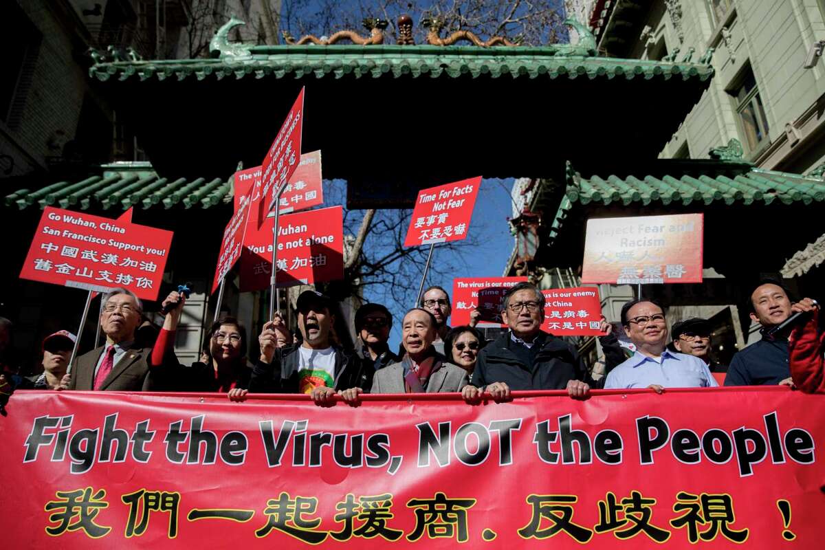 Hundreds of Chinatown residents along with local and state officials walk through the Dragon's Gate as they protest against racism in the Chinese community during a march down Grant Avenue from Chinatown's Portsmouth Square to Union Square in San Francisco on Feb. 29, 2020. The red banner that reads “Fight the Virus, NOT the People” in English and Mandarin will be the largest COVID-19-related object that the Smithsonian museum will add to its collection.