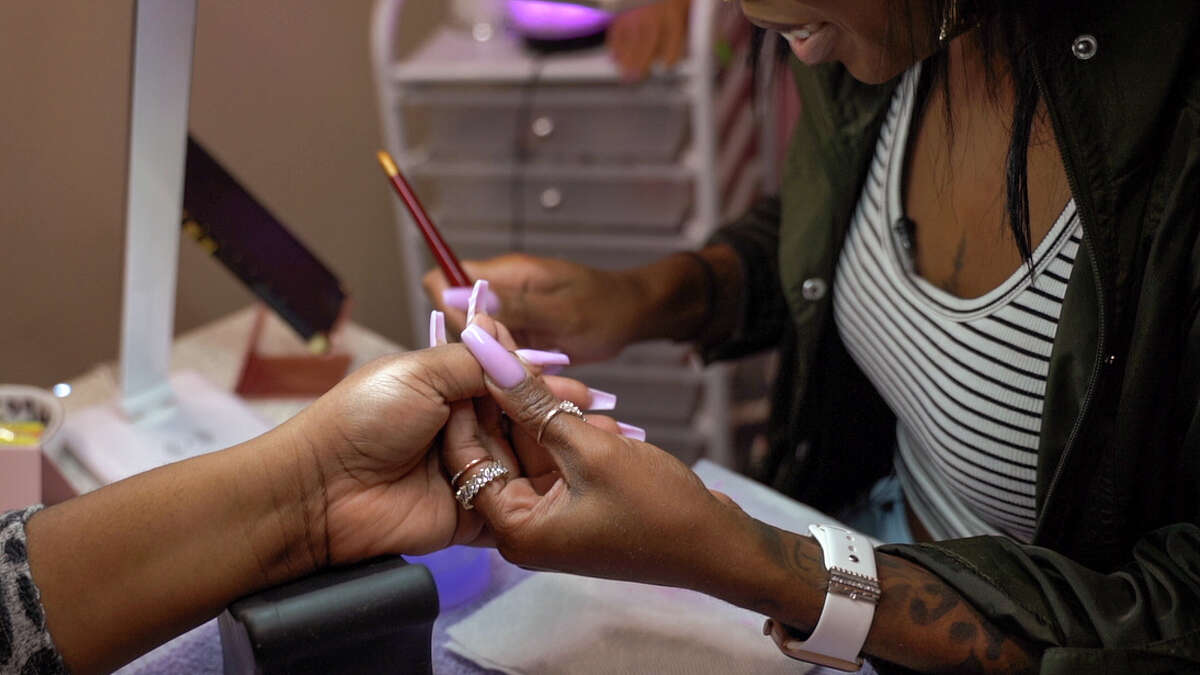 Local Houstonian, Krystina Woods, 32, is shown doing one of her clients, Mayurche Yarber's nails. Woods shared what it was like doing Olympic gold medalist, Simone Biles, nails for her Essence magazine cover story, "More Than a Medal."