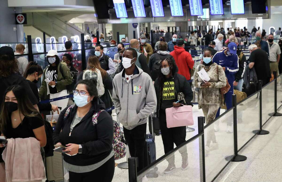 Passengers stand in line at a TSA checkpoint ahead of the Thanksgiving holiday Tuesday, Nov. 23, 2021, in Terminal C at George Bush Intercontinental Airport in Houston. Travel for Christmas is expected to be near pre-pandemic levels.