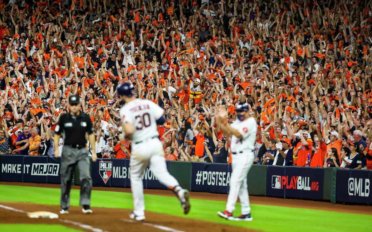 Astros fans cheer as Houston Astros right fielder Kyle Tucker (30) starts his run around the bases after hitting a three-run home run to give the Astros a 5-0 lead in the bottom of the eighth inning in Game 6 of the American League Championship Series on Friday, Oct. 22, 2021 at Minute Maid Park in Houston.