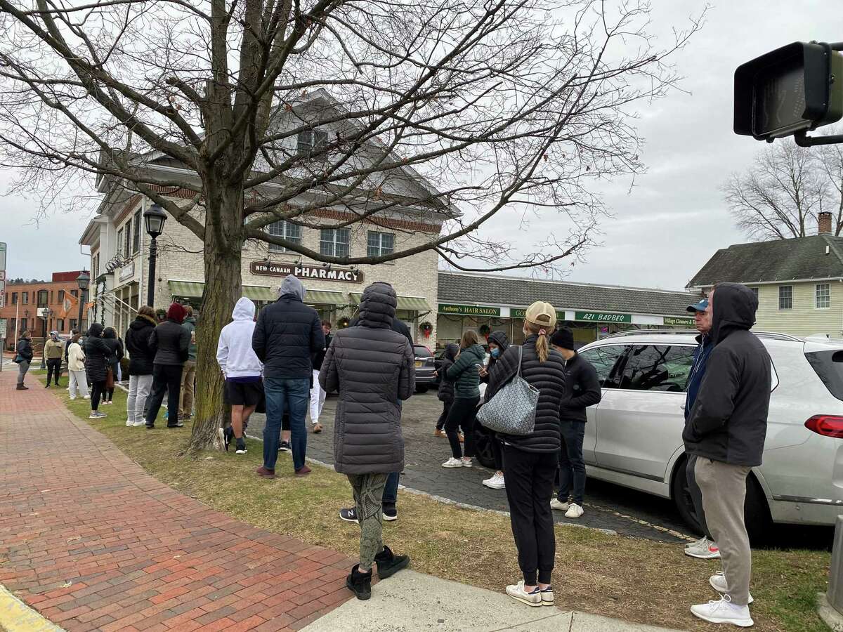 People stood in line waiting for vaccines and boosters at the New Canaan Pharmacy on East Avenue In New Canaan, on Saturday, Dec. 18, 2021.