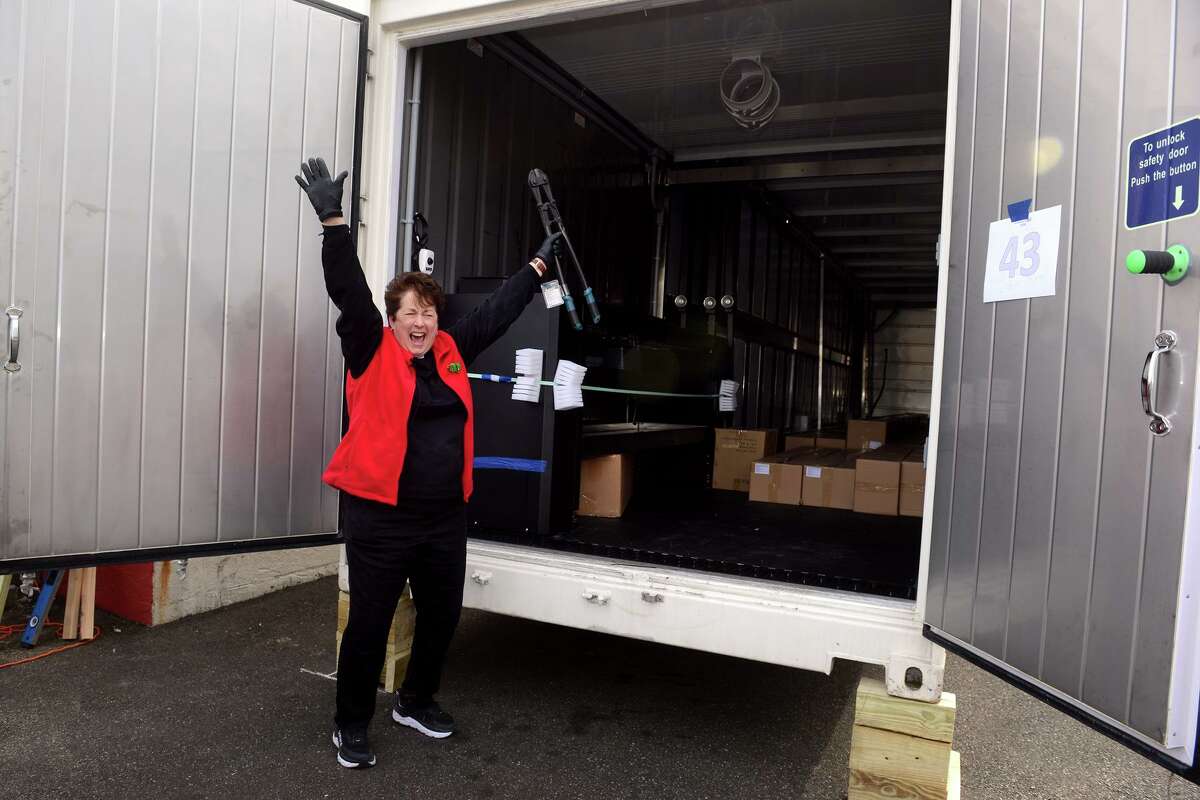 Rev. Sara Smith, founder and CEO of nOURish Bridgeport, cheers as she takes her first look inside the newly installed shipping container that will become part of the hydroponic farm currently under construction in Stratford, Conn. Dec. 21, 2021. The farm will grow and supply fresh vegetables for those in need in the greater Bridgeport area.
