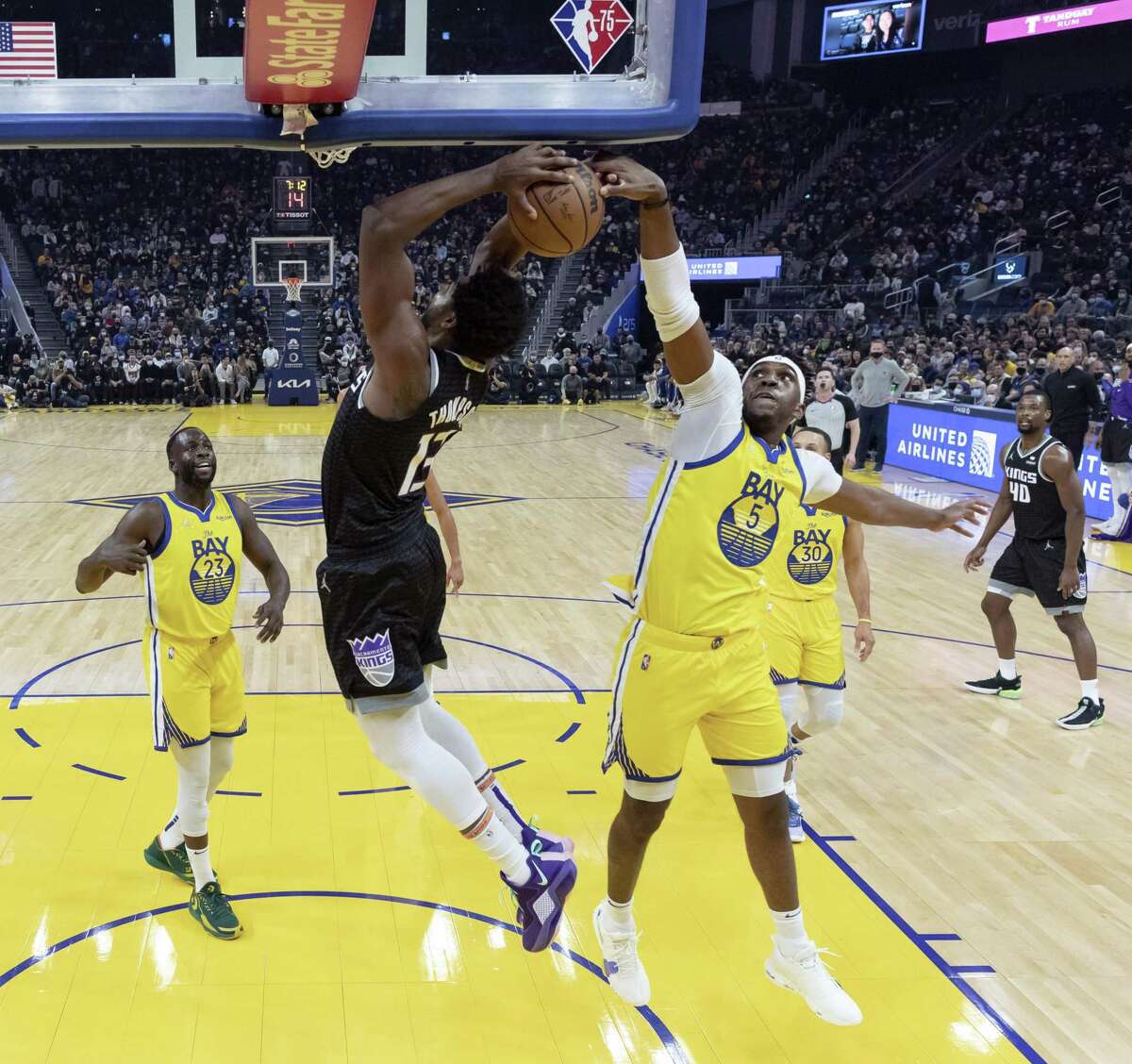 Kevon Looney (5) blocks a shot by Tristan Thompson (13) in the first half as the Golden State Warriors played the Sacramento Kings at Chase Center in San Francisco, Calif., on Monday, December 20, 2021.