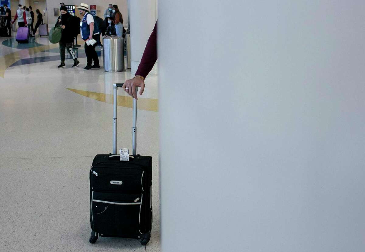 A traveler leans on his suitcase at San Antonio International Airport in San Antonio, Texas, on Dec. 21, 2021.