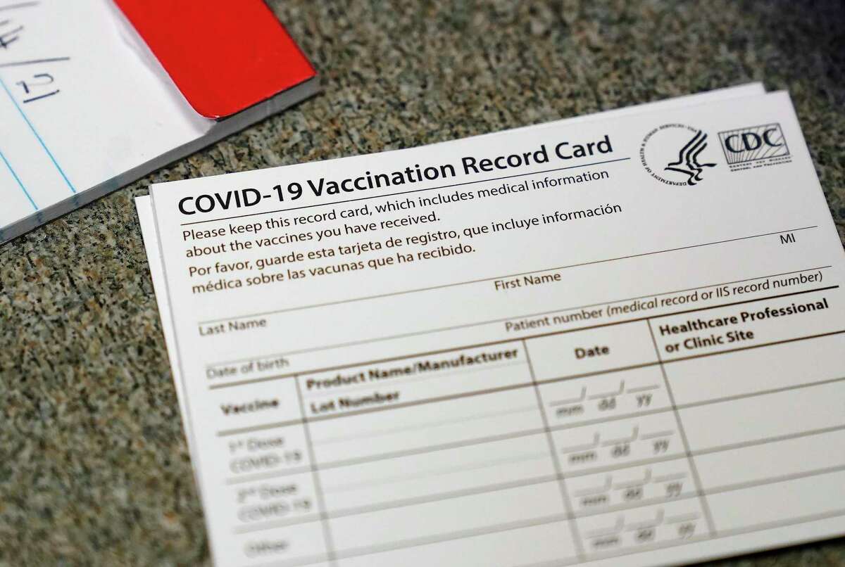 File photo, a COVID-19 vaccination record card is shown at Seton Medical Center in Daly City, Calif.