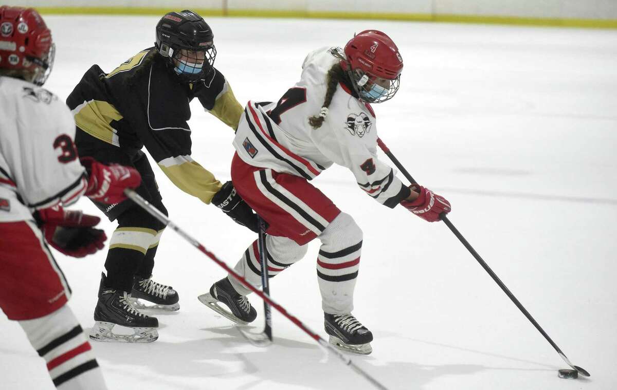 New Canaan's Kaleigh Harden (4) controls the puck against Trumbull/St. Joseph during the FCIAC girls ice hockey semifinals at the Darien Ice House on Thursday, March 18, 2021.