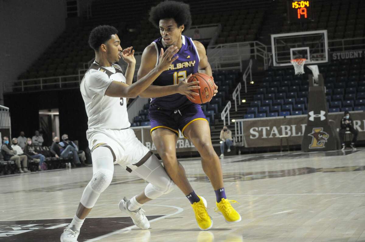University at Albany freshman forward Justin Neely drives against Evan Taylor of Lehigh. Neely had a double-double of 11 points and 14 rebounds.