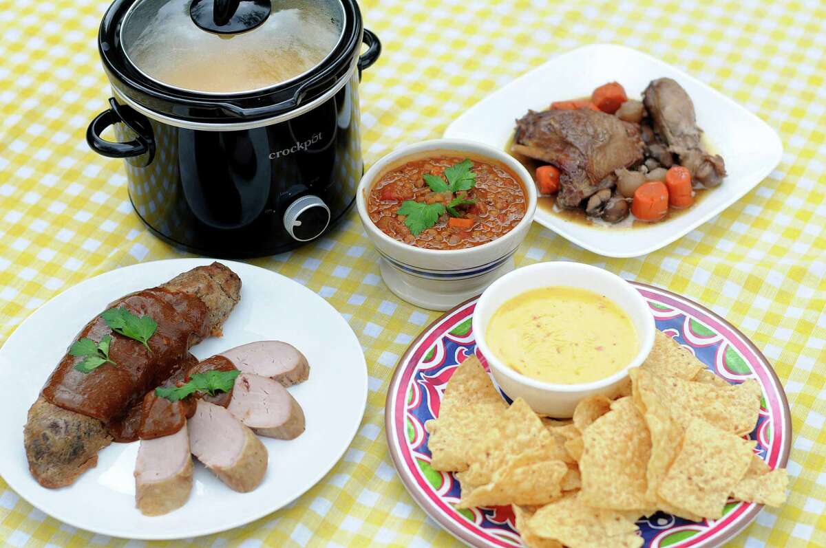 A selection of dishes made in a slow cooker including (clockwise from front left) Slow Cooker Honey Mustard Pork Tenderloin, Vegan Slow Cooker Lentil Soup, Slow Cooker Coq Au Vin and Classic Slow Cooker Queso