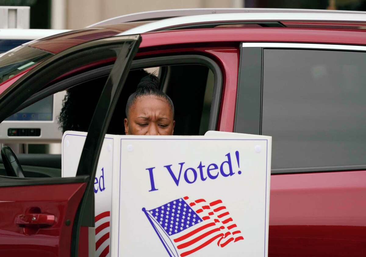 In this Oct. 15, 2020, file photo, a voter makes their choice from a vehicle outside the American Airlines Center in Dallas.