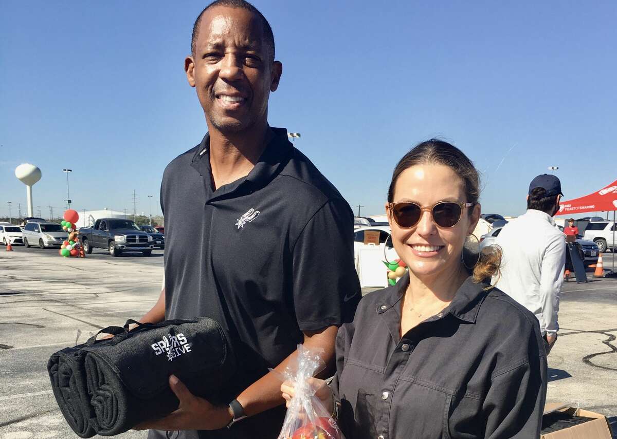 Former Spurs star turned TV analyst Sean Elliott and his wife Claudia Zapata volunteered at an H-E-B-sponsored San Antonio Food Bank distribution on Wednesday, Dec. 22 at the AT&T Center.