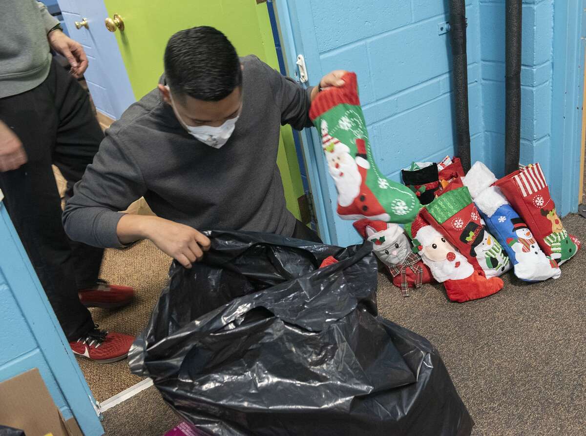 Volunteer Mark Hawkson of Albany fills a bag full of Christmas stockings stuffed with candy for 500 foster kids at Victory Church on Tuesday, Dec. 21, 2021 in Colonie, N.Y (Lori Van Buren/Times Union)