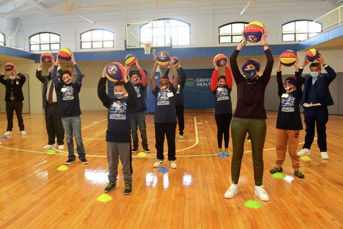Ansonia school students are joined by U.S. Rep. Rosa Delauro and Mayor David Cassetti as they do warm-up drills with members of the Harlem Wizards basketball team following a rededication ceremony in the newly renovated Ansonia Armory gymnasium, in Ansonia, Conn. Dec. 22, 2021.