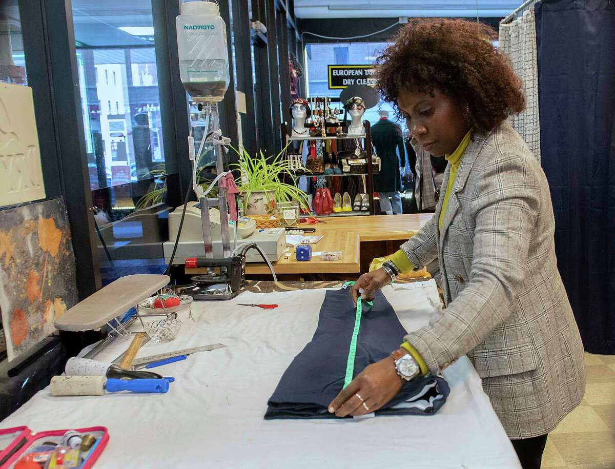 Mo Rabiu works in her shop European Tailoring and Alterations on Wednesday, Dec. 22, 2021 in Albany, N.Y.