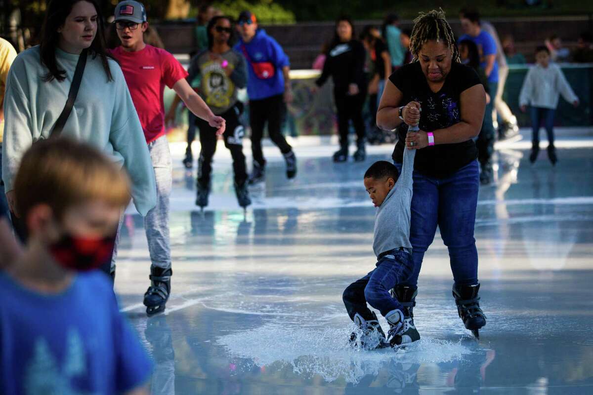 A boy slips in the melted ice on a warm mid December day three days before Christmas Day at Discovery Green, Wednesday, Dec. 22, 2021, in Houston.