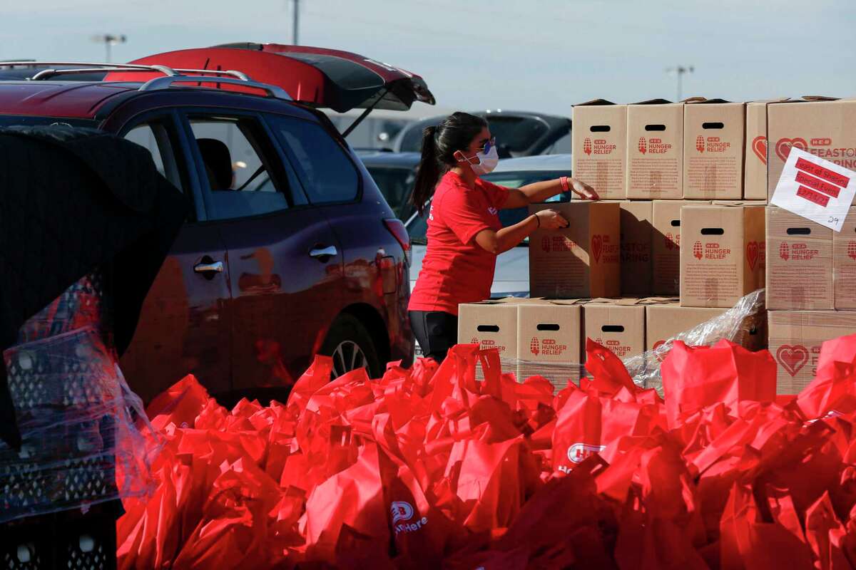 Desiree Castro, an H-E-B partner, organizes boxes as she volunteers during the H-E-B Feast of Sharing event at the AT&T Center in San Antonio on Wednesday afternoon. Vehicles lined up to pick up free food and holiday goodies from H-E-B, Spurs Give and the San Antonio Food Bank from 11 a.m. to 2 p.m.