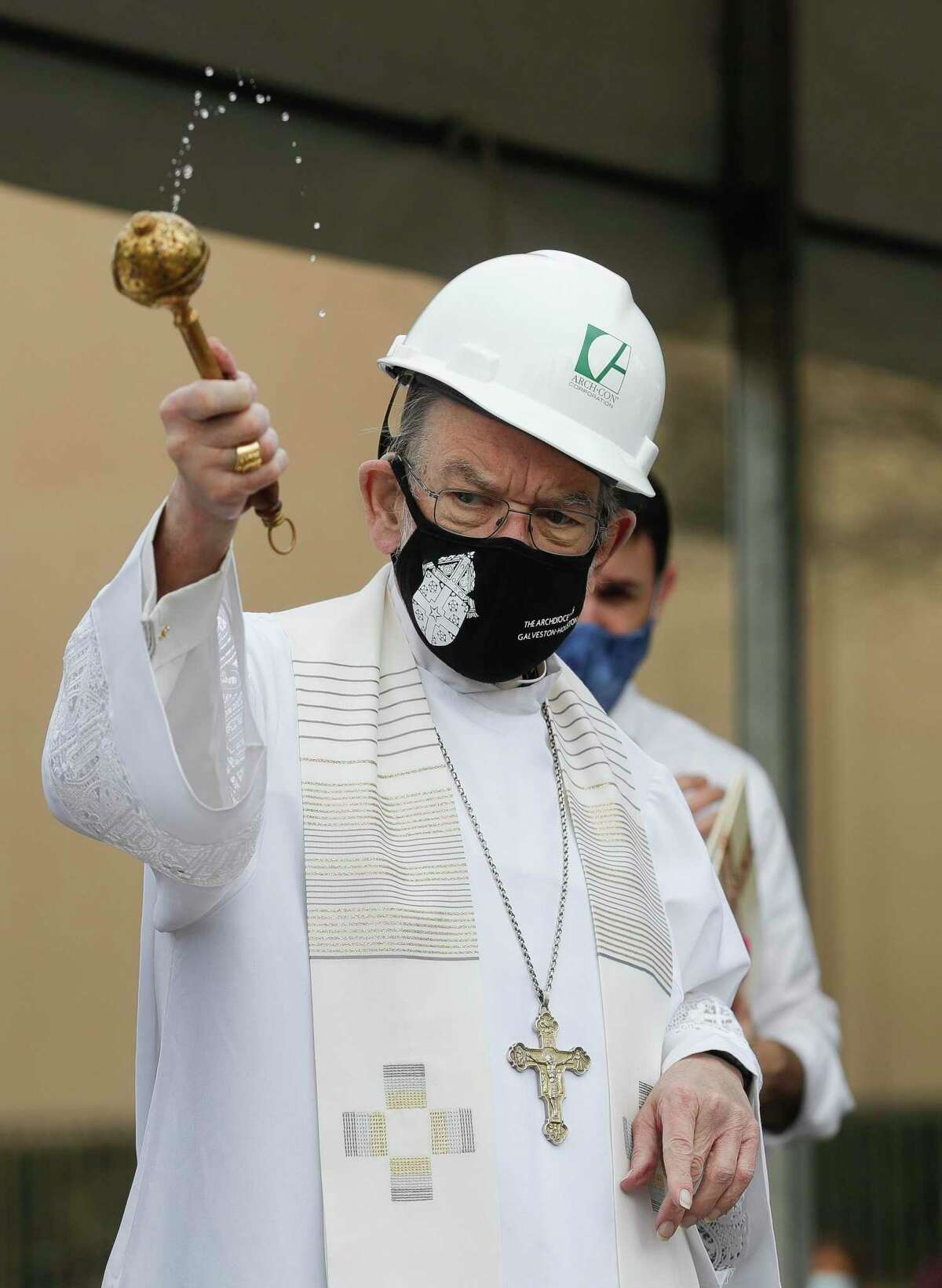 Bishop George Sheltz, former pastor at St. Anthony of Padua Catholic Church, spreads holy water on the future site of the Our Lady of Angels chapel, Saturday, Feb. 6, 2021, in The Woodlands.