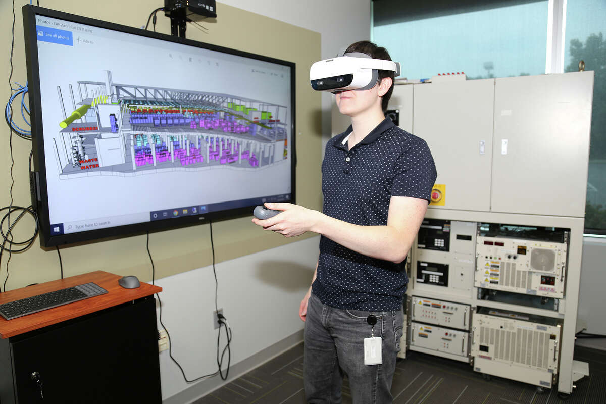 Grad student Sean O'Grady using a virtual reality headset system that is part of a training test-bed of the Advanced Manufacturing Performance Center at SUNY Polytechnic Institute in Albany.  The program provides the user with the experience of conducting safety checks prior to completion of the shutdown process for an Edwards Proteus plasma abatement system. The program takes a student through the experience of an emergency power down that builds upon actual in-person training.