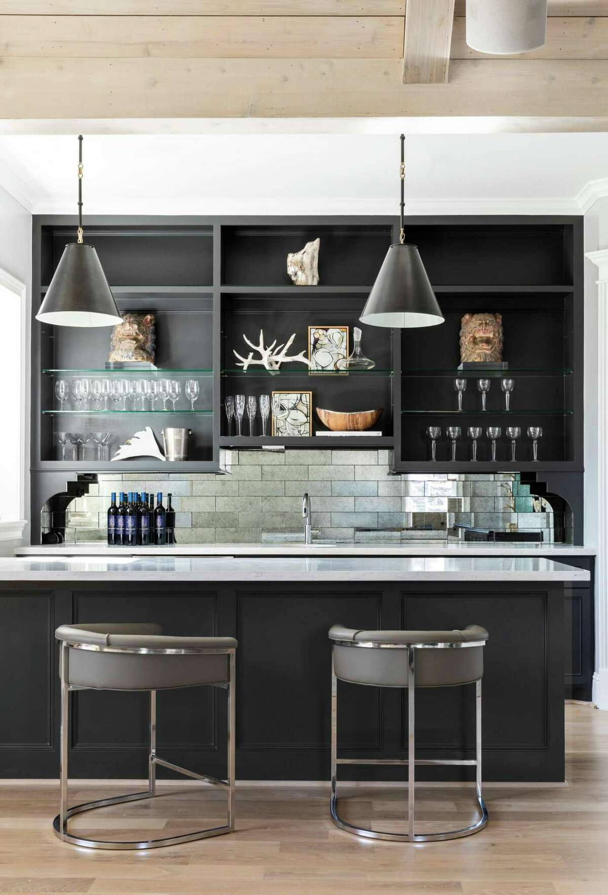 Black accents and deep, rich colors are on trend for 2022, as shown in this home bar — another major trend — designed by Houston interior designer Linda Eyles of Linda Eyles Design.