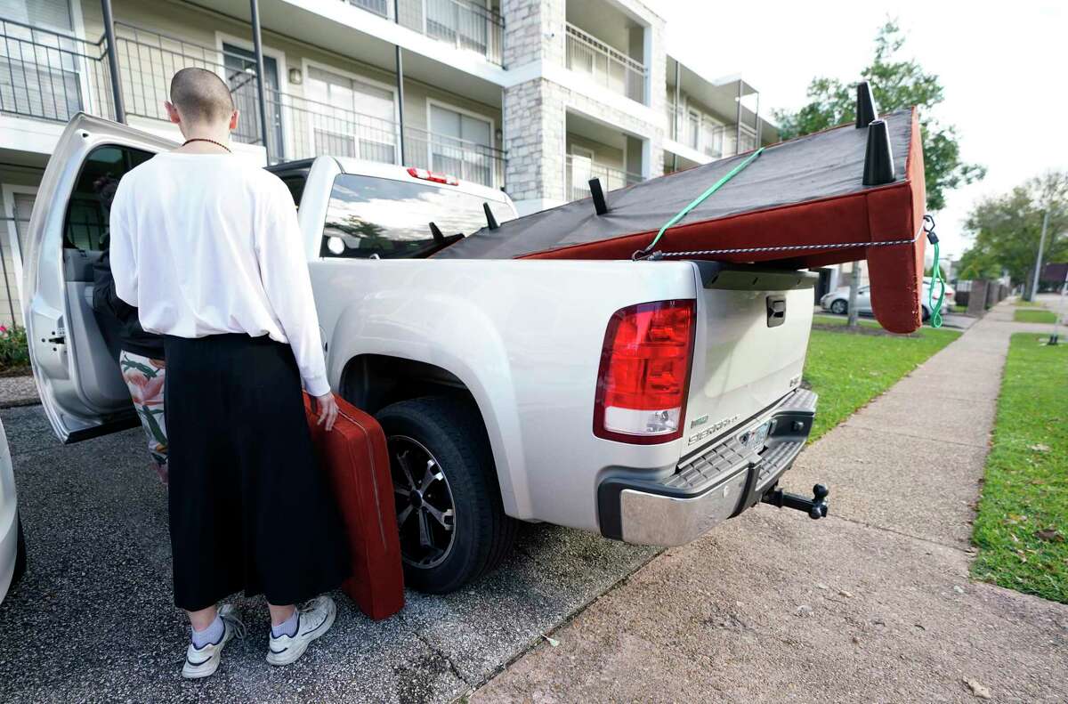 Audrey Hall loads a vehicle while moving Sunday, Dec. 19, 2021 in Houston. Audrey decided to move because of an apartment rent increase.