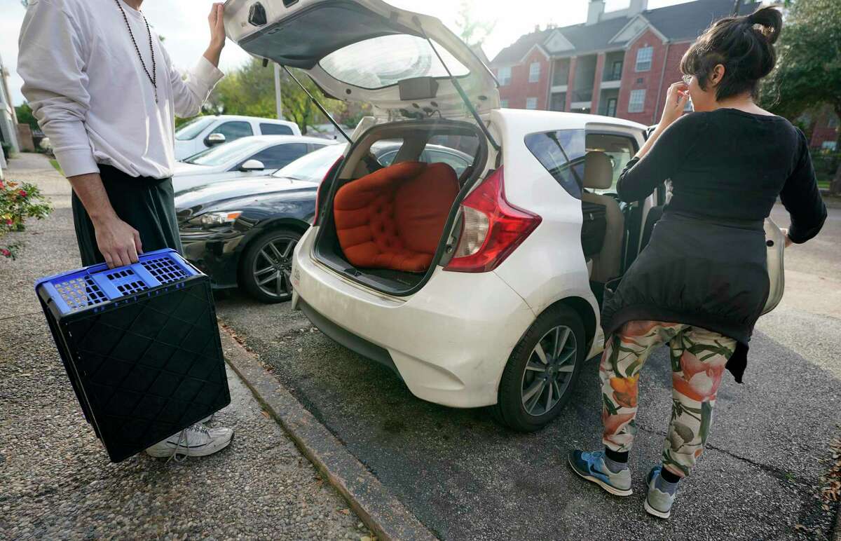 Audrey Hall, left, is helped by Lisa Longoria, right, to load vehicle while moving Sunday, Dec. 19, 2021 in Houston. Audrey decided to move because of an apartment rent increase.