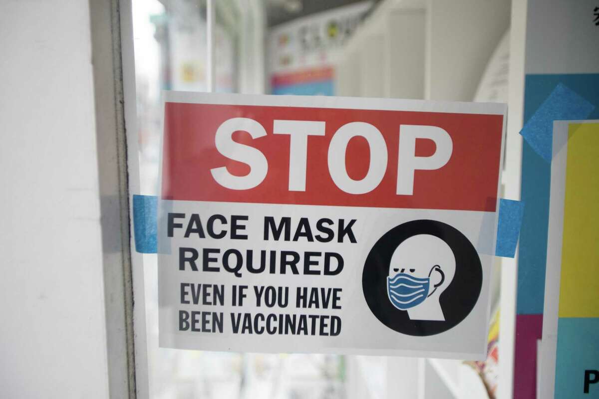 A sign in the window of a business in Chinatown on Stockton Street reminds customers of the indoor mask mandate in San Francisco, Calif. on August 5, 2021.