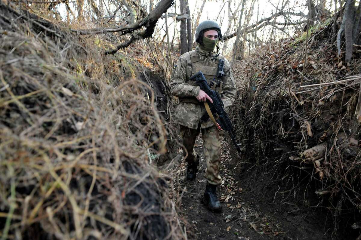 A Ukrainian serviceman walks along a trench on the frontline with Russia-backed separatists near the village of Talakivka, Donetsk region, on Wednesday, Nov. 24, 2021.