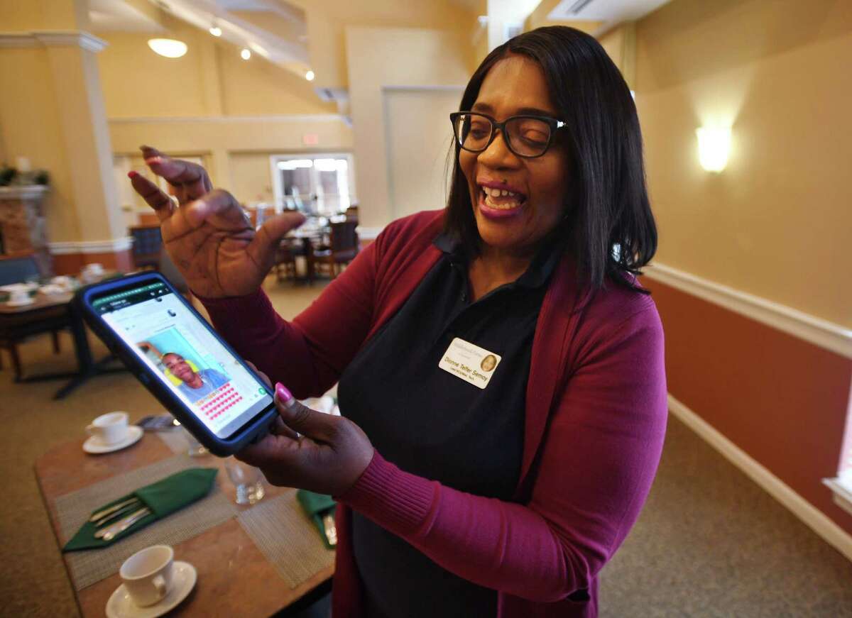 Dionne Semoy smiles as she reads a phone message from Odane Campbell, a 33-year-old disabled Jamaican man that she and her family have adopted into their care in Jamaica. Semoy, the senior lead resident care associate at Middlebrook Farms in Trumbull, hopes to one day move Campbell to the United States.