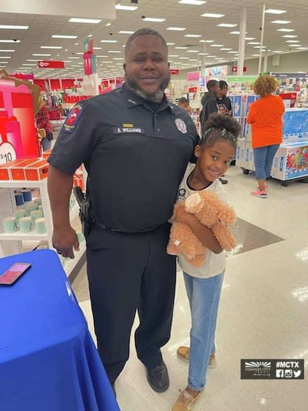 A police police officer poses with a child on Saturday, Dec. 18, at the annual Shop with a Cop event.