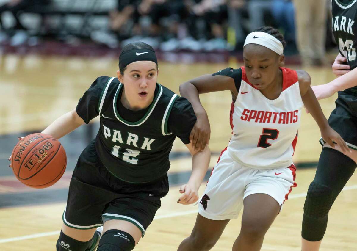 Kingwood Park guard Matti McDaniel (12) dribbles the ball toward the basket while under pressure from Porter point guard D'Asia Williams (2) during the second quarter of a District 20-5A girls basketball game at Porter High School, Saturday, Feb. 6, 2021 in Porter.