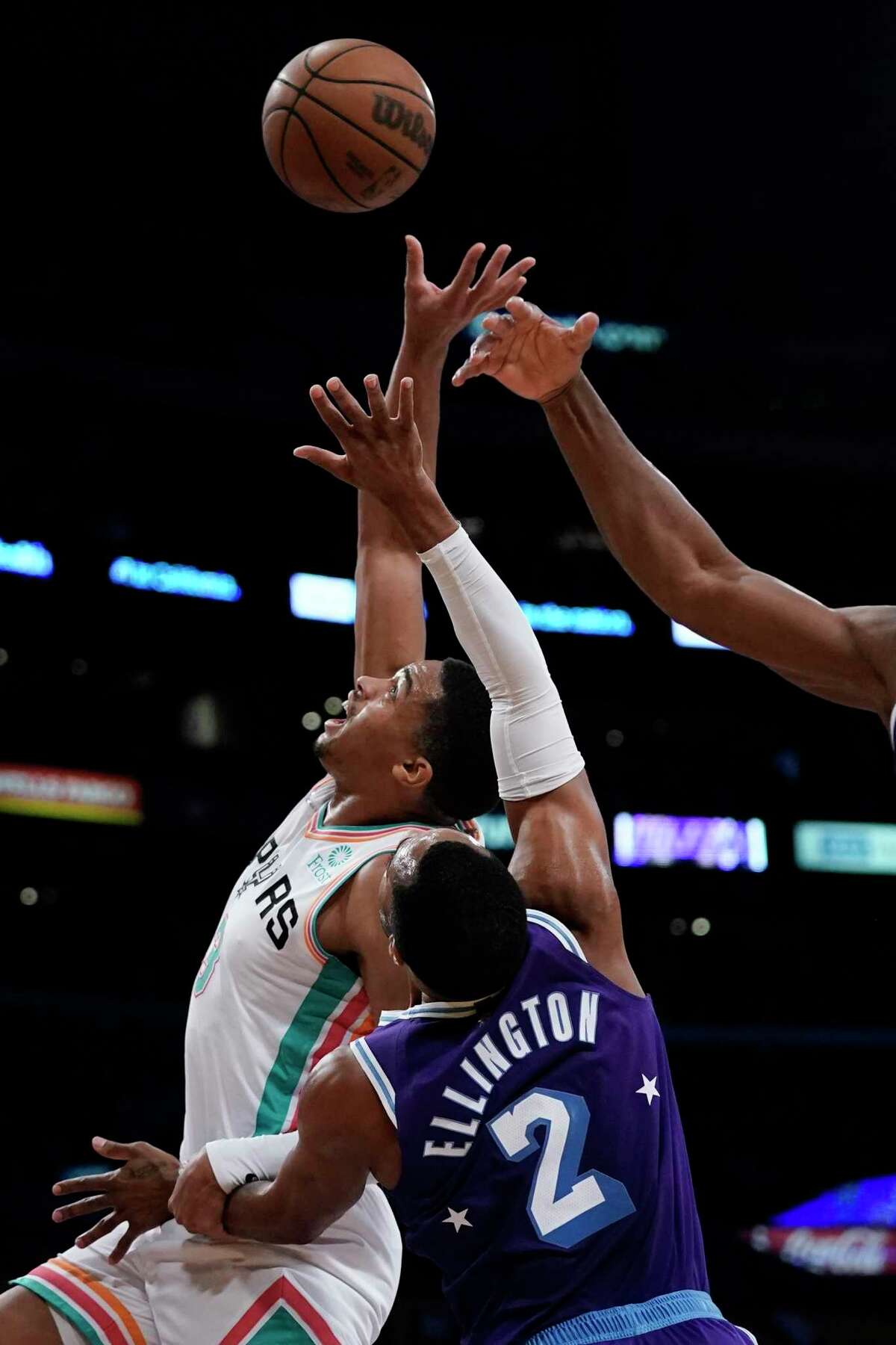 San Antonio Spurs' Keldon Johnson, left, fights for a rebound with Los Angeles Lakers' Wayne Ellington during first half of an NBA basketball game Thursday, Dec. 23, 2021, in Los Angeles. (AP Photo/Jae C. Hong)