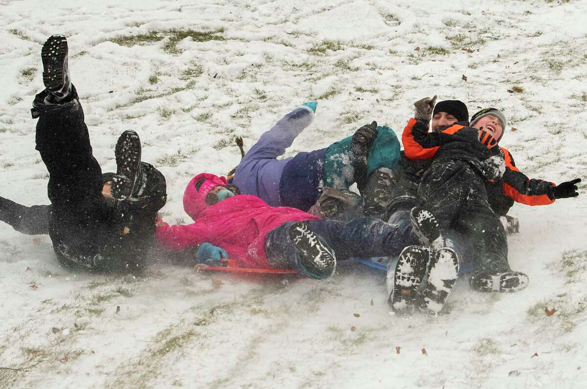 Heidi Pullen, left, Colin Snyder, second from right, and their kids Anastasia Snyder, 9, Isabella Snyder, 11, and Colin Jr., 7, enjoy the first significant snowfall by sledding at Frear Park on Friday, Dec. 24, 2021 in Troy, N.Y.