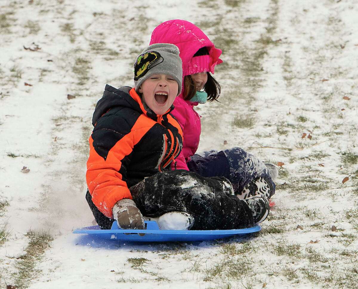 Colin Snyder, Jr., 7, and his sister Anastasia, 9, enjoy the first significant snowfall by sledding at Frear Park with their family on Friday, Dec. 24, 2021 in Troy, N.Y.