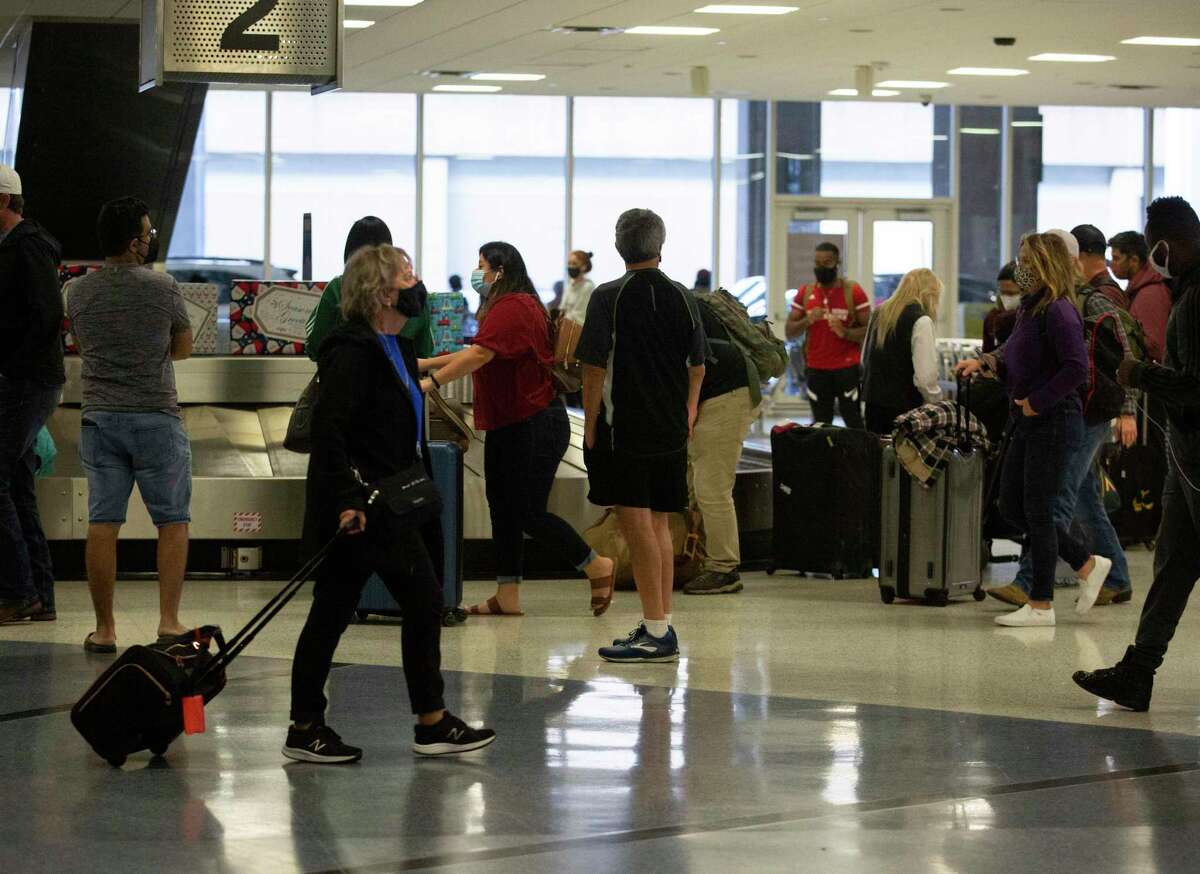 People waiting at baggage claim at Terminal C Friday, Dec. 24, 2021, at George Bush International Airport in Houston.