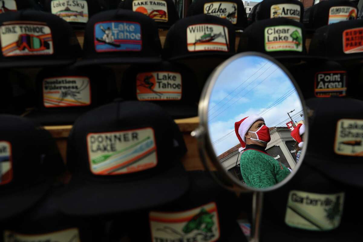 Raoul Ruffino of Boulder, Colo., looks at caps from the Bart Bridge booth while shopping at the Telegraph Avenue Holiday Street Fair in Berkeley.