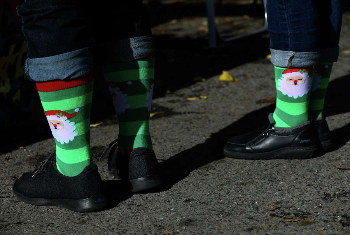 Holiday shoppers Raoul Ruffino of Boulder, Colo., and Cynthia Austen of Danville don matching Santa socks at the Berkeley street fair. Austen said she’s brought her kids to the event for decades, and it was Ruffino’s first visit.