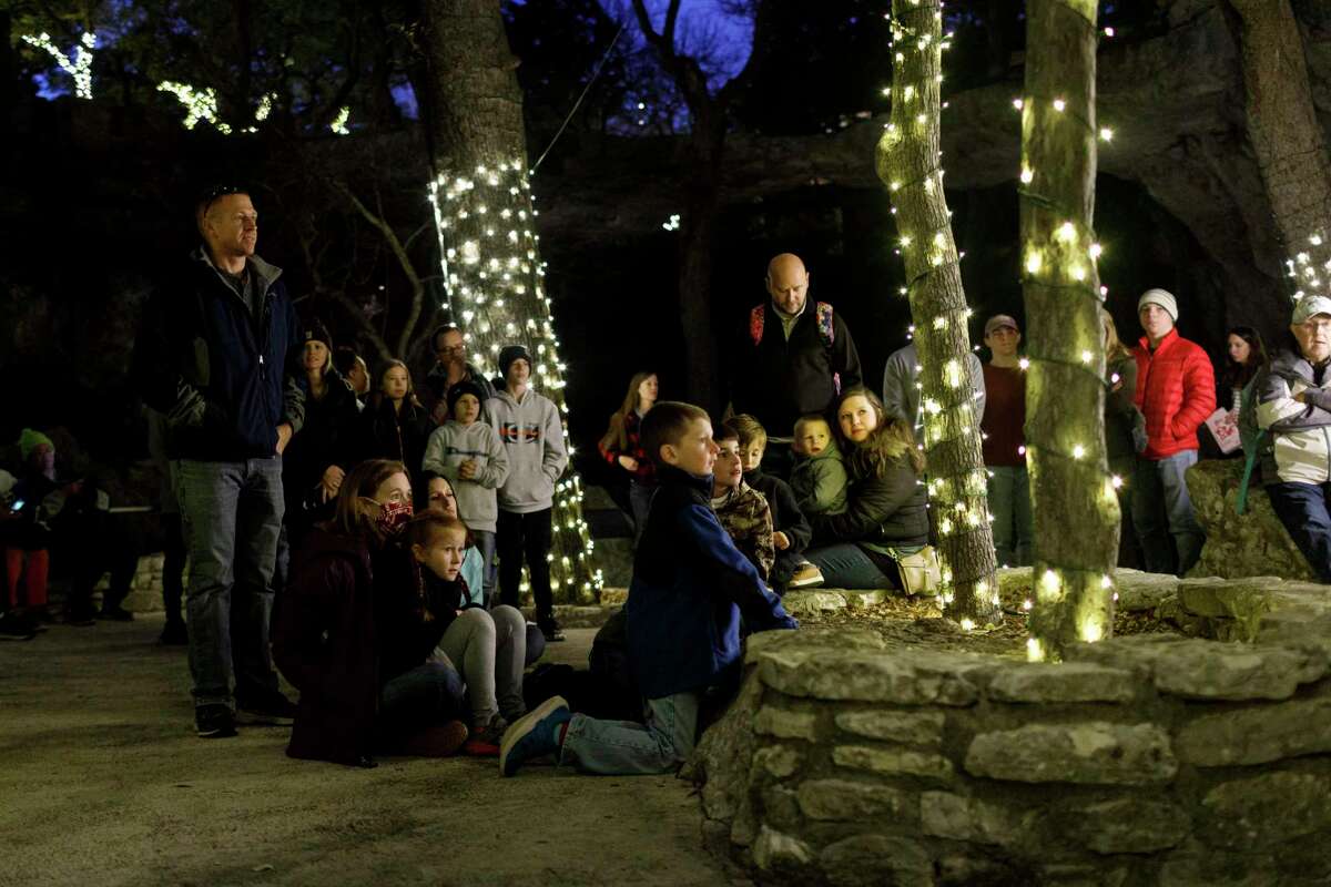 People of all ages listen to musicians from Living Word Lutheran Church sing Christmas carols before entering the caverns for a caroling tour during Christmas at the Caverns at Natural Bridge Caverns in San Antonio, Texas, Saturday, Dec. 11, 2021.