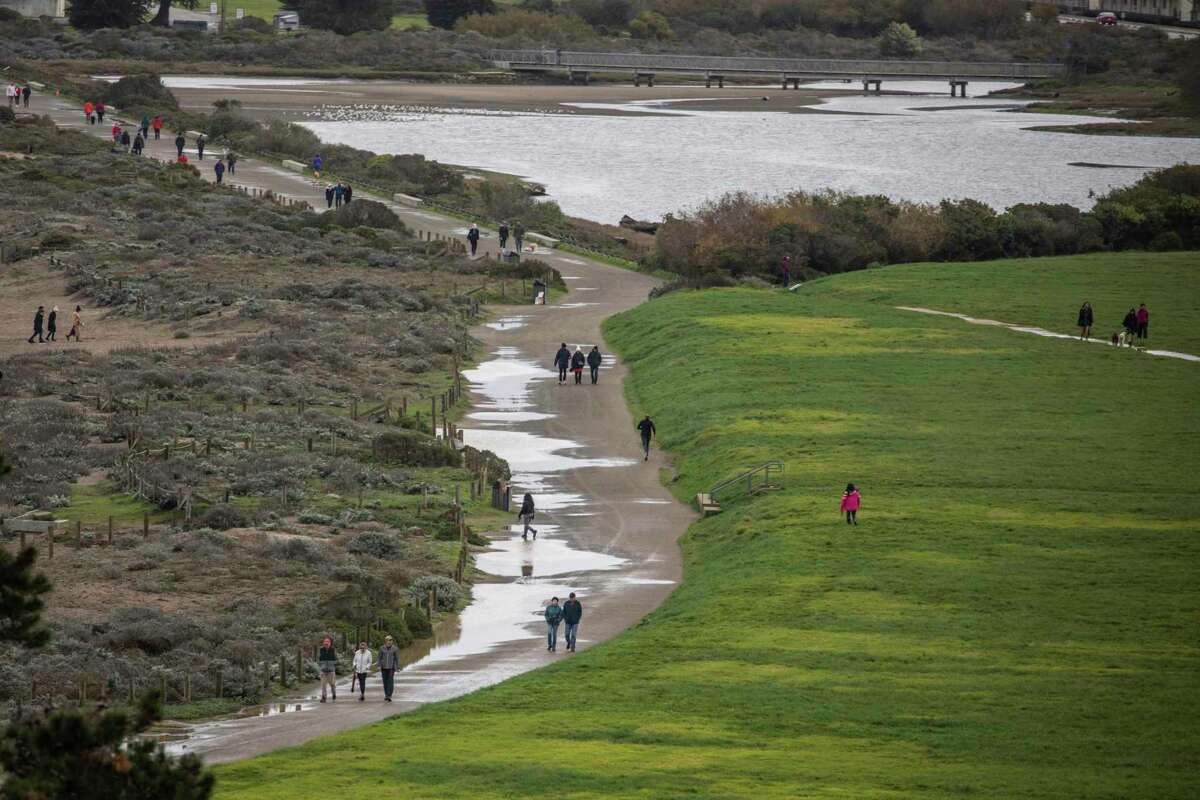 Pedestrians walk along a water-clogged path on San Francisco’s Crissy Field on Christmas Day.