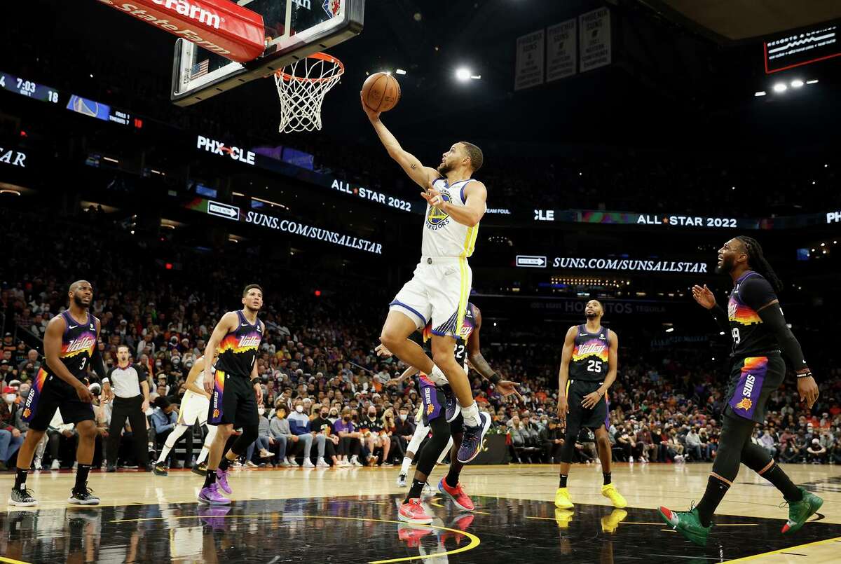 PHOENIX, ARIZONA - DECEMBER 25: Stephen Curry #30 of the Golden State Warriors lays up a shot against the Phoenix Suns during the first half of NBA game at Footprint Center on December 25, 2021 in Phoenix, Arizona. 