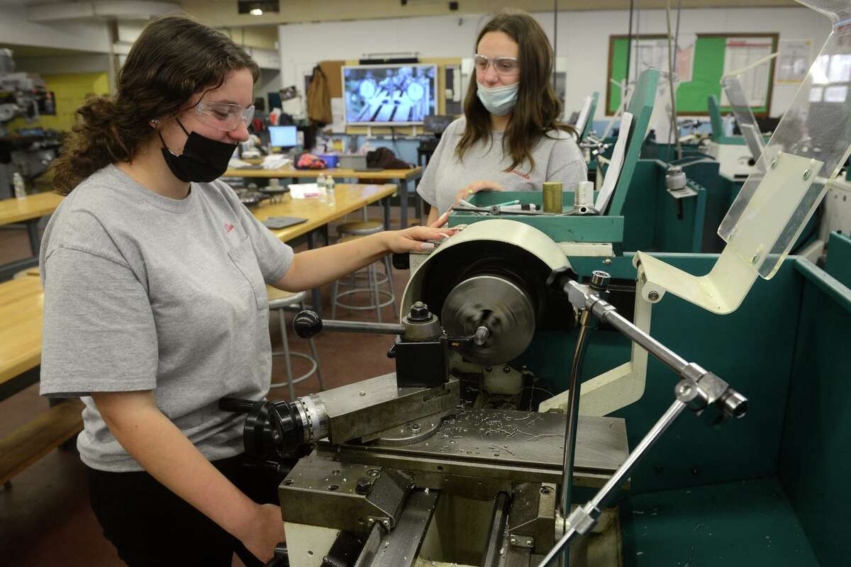 Sophomores Rosina Tiano, left, of East Haven, and Angelina Ceniccola, of New Haven, work during a precision-machining class at Platt Technical High School, in Milford, Conn., on Nov. 17, 2021.