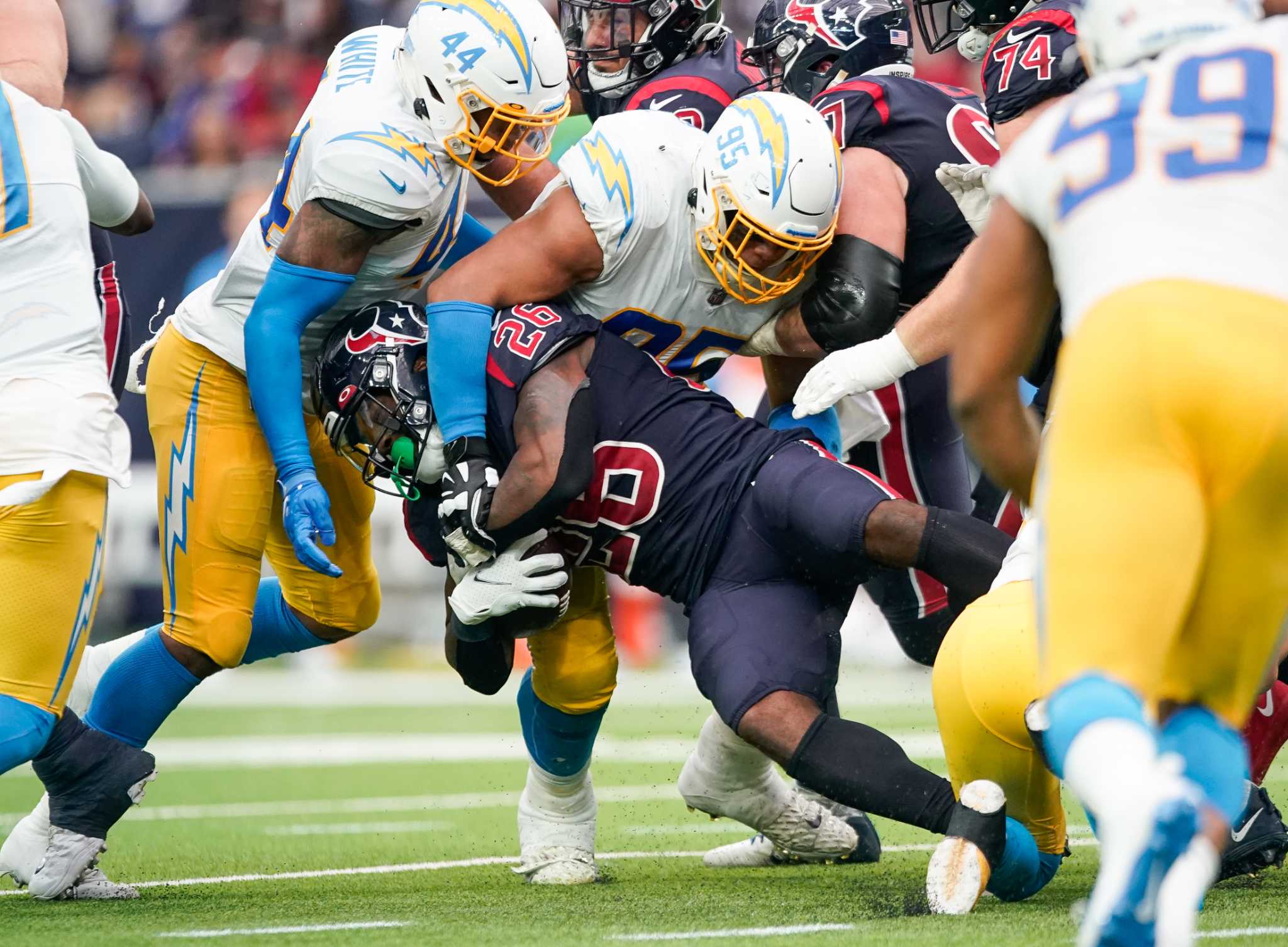 Los Angeles Chargers' Josh Palmer (5) is tackled by Houston Texans' Tremon  Smith (24) during the second half of an NFL football game Sunday, Dec. 26,  2021, in Houston. The Texans won