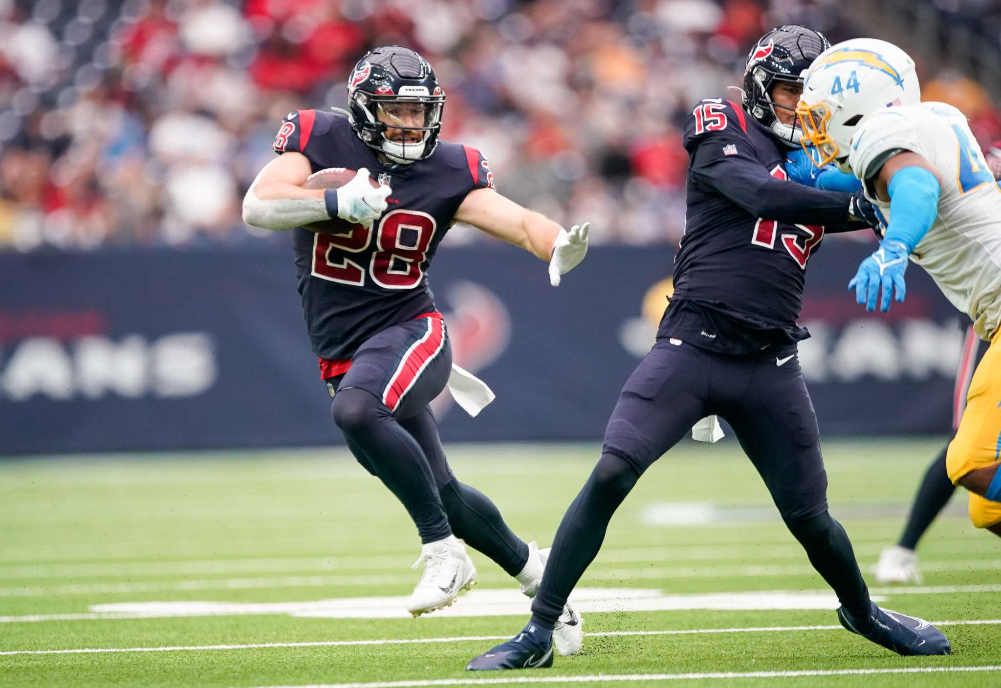 Los Angeles Chargers' Josh Palmer (5) is tackled by Houston Texans' Tremon  Smith (24) during the second half of an NFL football game Sunday, Dec. 26,  2021, in Houston. The Texans won