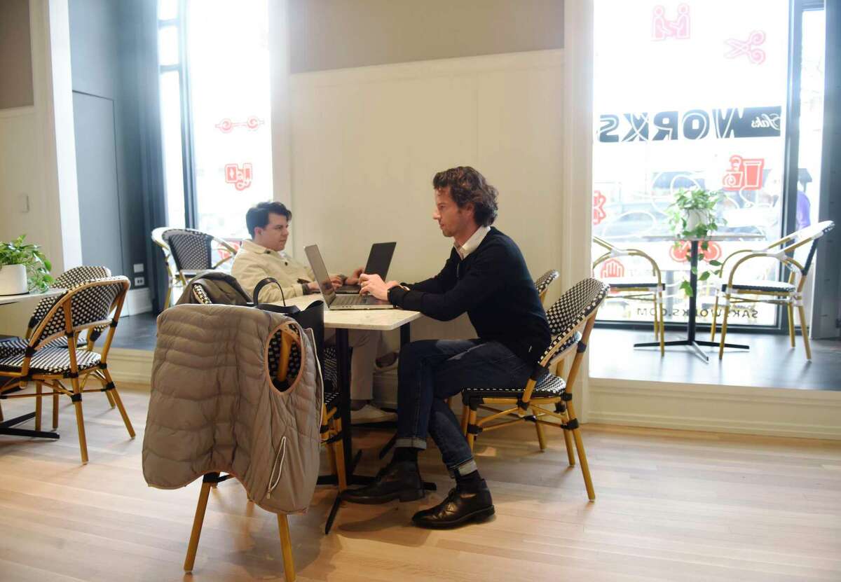 Miguel Salinas, left, and Jan Rutgers, of Jan George Interior Design, work in the public cafe at SaksWorks in Greenwich, Conn. Thursday, Dec. 16, 2021. Located in the former Ralph Lauren showroom, SaksWorks aims to foster a work-life balance through amenities including work and meeting spaces, programmed events for members, private event spaces, and a public cafe and restaurant. While much of the space if reserved for members only, the contemporary American restaurant, Ruby & Bella's, as well as the cafe are open to the public.